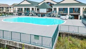 Una piscina rodeada de edificios con balcones y terrazas.