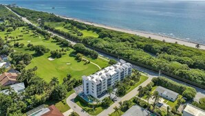 An aerial view of a coastal resort with a golf course, beachfront, and a multi-story hotel with a pool. - Lux 2 Bedroom - 2 Bathroom w/Balcony Directly Across from the Beach - Boca Raton (Boca Raton)