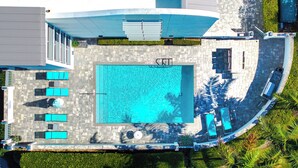 An aerial view of a swimming pool area with lounge chairs and a covered seating area. - Lux 2 Bedroom - 2 Bathroom w/Balcony Directly Across from the Beach - Boca Raton (Boca Raton)