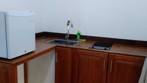A compact kitchen with a refrigerator, sink, and wooden cabinets. - Sanduhan Villa, Stay in Sri Lanka! (Warakapola)