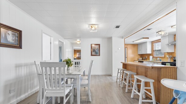Una cocina moderna con armarios blancos, una isla de madera y taburetes de bar.