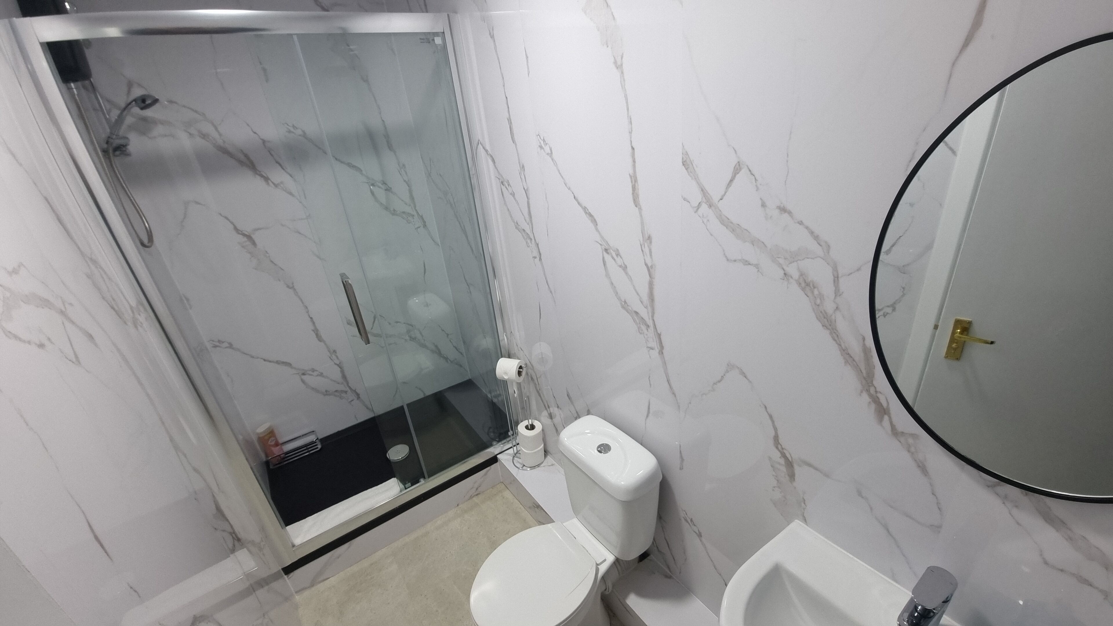 A bathroom with a toilet, bidet, and a glass-enclosed shower.