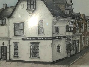 Un edificio blanco con múltiples ventanas y un letrero que dice "Ye Olde Hotel".