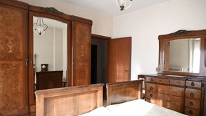 Una camera da letto con un letto di legno, una cassettiera e un armadio.