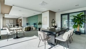A modern kitchen with a central island, dining area with chairs, and a large window with a view. - La Brisa | Pool - terrace - gym (Estepona)