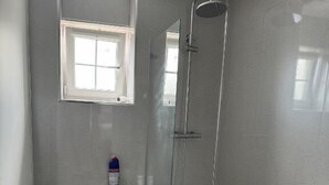 A bathroom with a toilet, a window, and a bathtub. - Glass Street Apartment (Glenrothes)
