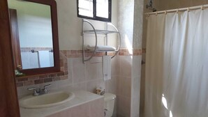 A bathroom with a sink, toilet, and shower curtain. - Hotel Playa Bonita (Tela)
