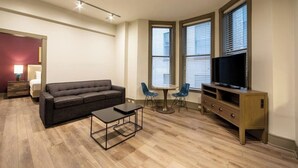 Una sala de estar moderna con un sofá, una mesa de centro, un mueble para la televisión y dos sillones.