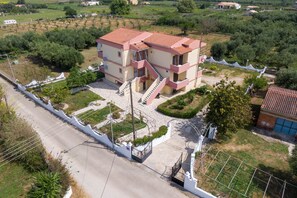 A multi-story building with a red-tiled roof, a central staircase, and a paved courtyard.