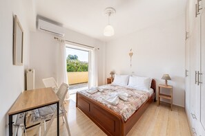 A bedroom with a bed, bedside tables, a desk, and a chair.