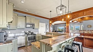 Cocina con encimeras de granito, electrodomésticos de acero inoxidable y armarios de madera.
