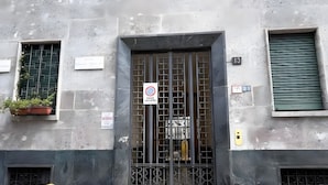 A building with a gated entrance, multiple windows, and a sign indicating no parking.