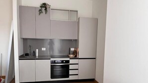 A compact kitchen with a built-in oven, a sink, and cabinets.