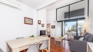 Un espacio de estar moderno con comedor, un sofá y un televisor.