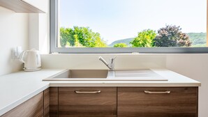 A kitchen with a window, a sink, and wooden cabinets.