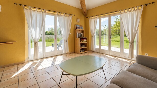 Una habitación con una mesa verde, un sofá y una estantería.