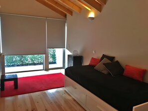 Ein modernes Schlafzimmer mit einem Bett, einem Nachttisch und einem roten Teppich.