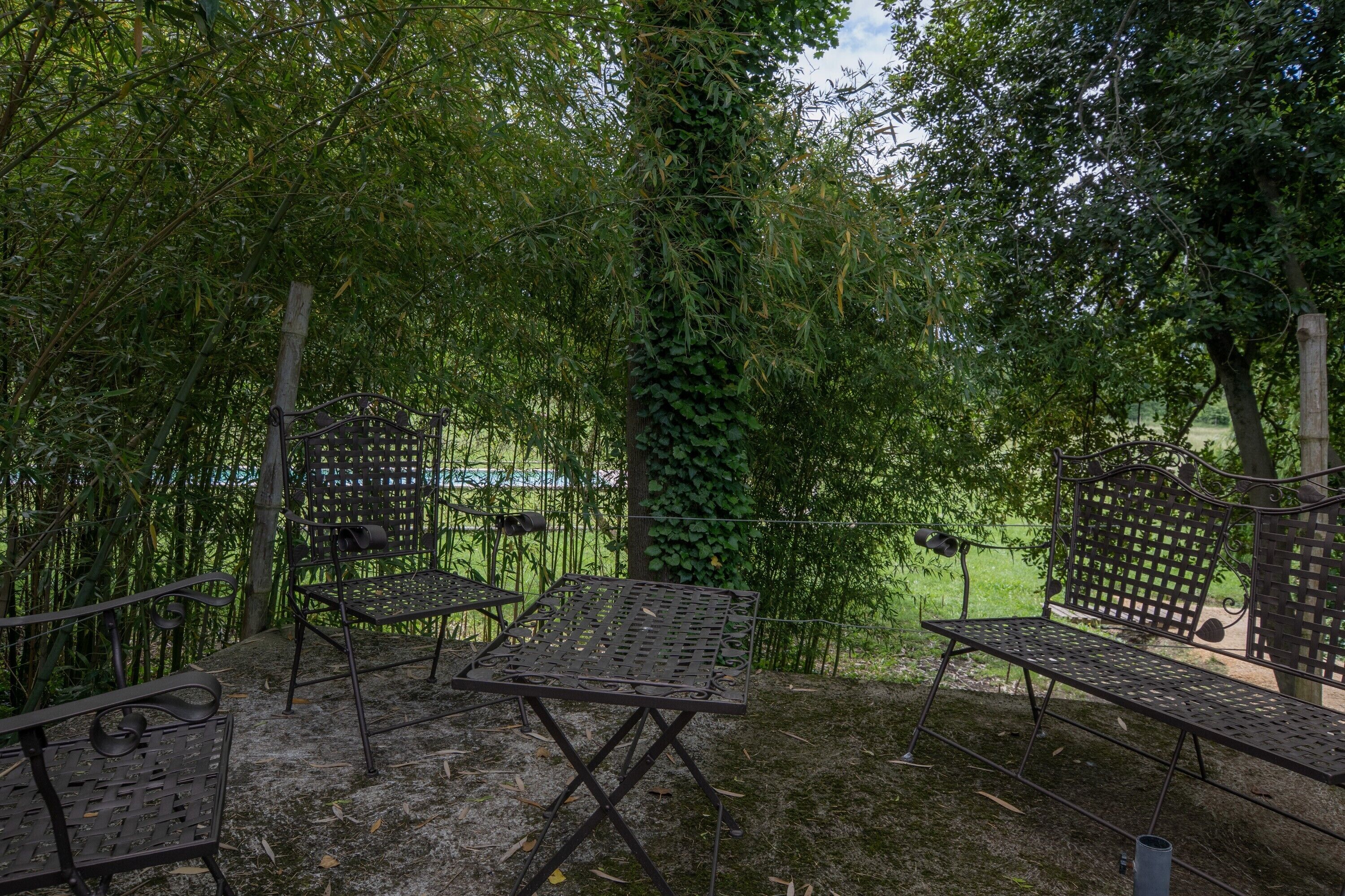A garden with metal furniture and a fence.