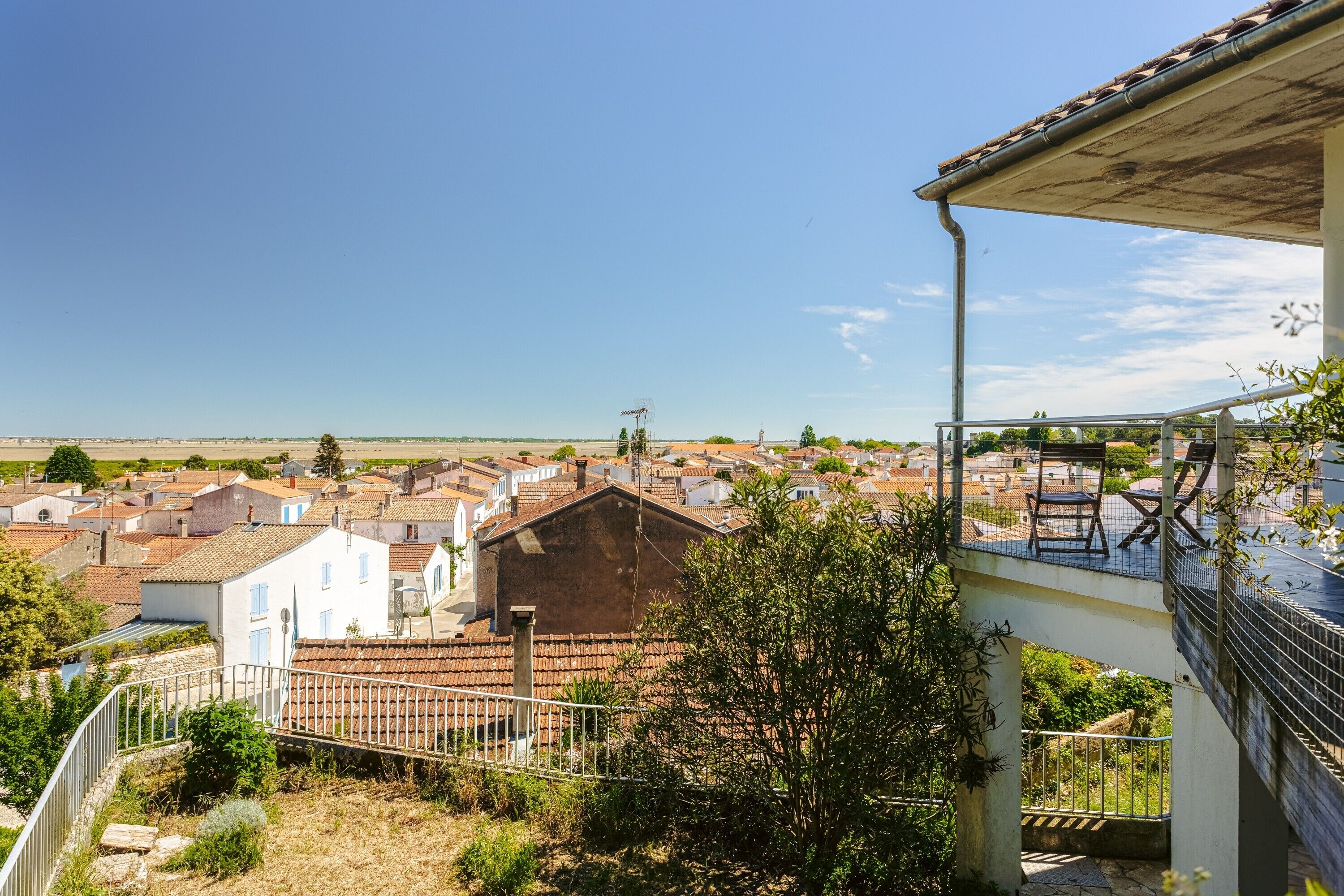 Un barrio residencial con casas, un balcón y cielo despejado.