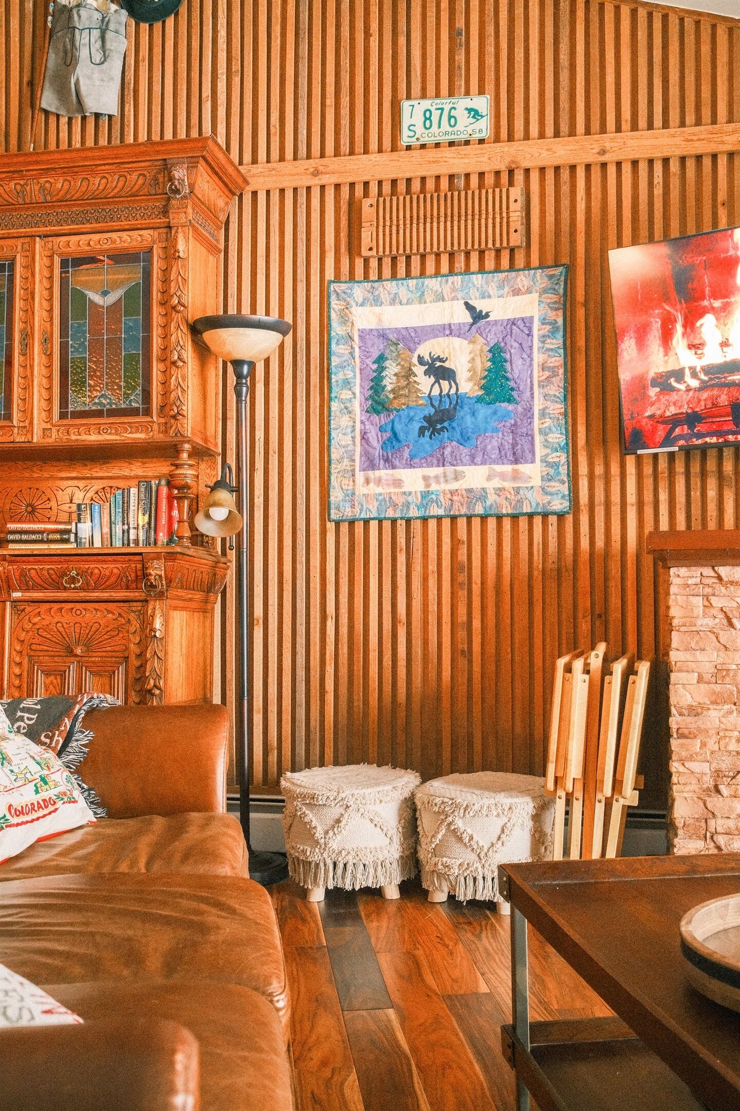 Une pièce chaleureuse avec des boiseries, une tapisserie matelassée, une bibliothèque et une cheminée.