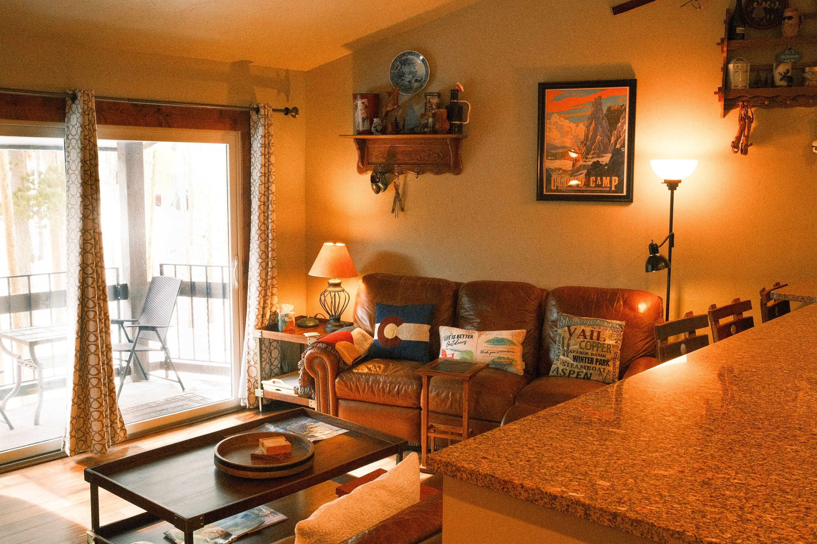 A cozy living room with a leather sofa, a coffee table, and a dining area with a granite countertop.