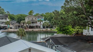 A waterfront property with multiple houses, a dock, and a small water feature. - Ocean Lakes T36 (Myrtle Beach)