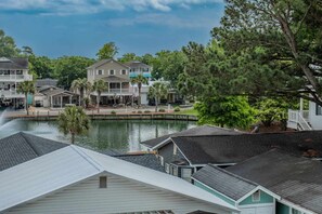 A waterfront property with multiple houses, a dock, and a small water feature.