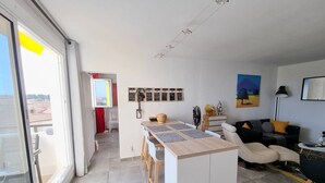 A modern living room with a kitchen area, a dining table, and a sofa. - Superb apartment completely renovated 4EST211 (LE BARCARES)