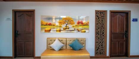 A room with a bed, two doors, and a wall-mounted artwork.