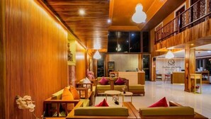 A spacious lobby with wooden paneling, comfortable seating, and a reception area.