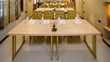 A conference room with a long table, multiple chairs, and a small flower centerpiece.