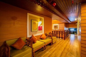 A wooden interior with a sofa and cushions, a framed picture, and a staircase leading to another level. - Ratana boutique resort (Klaeng)