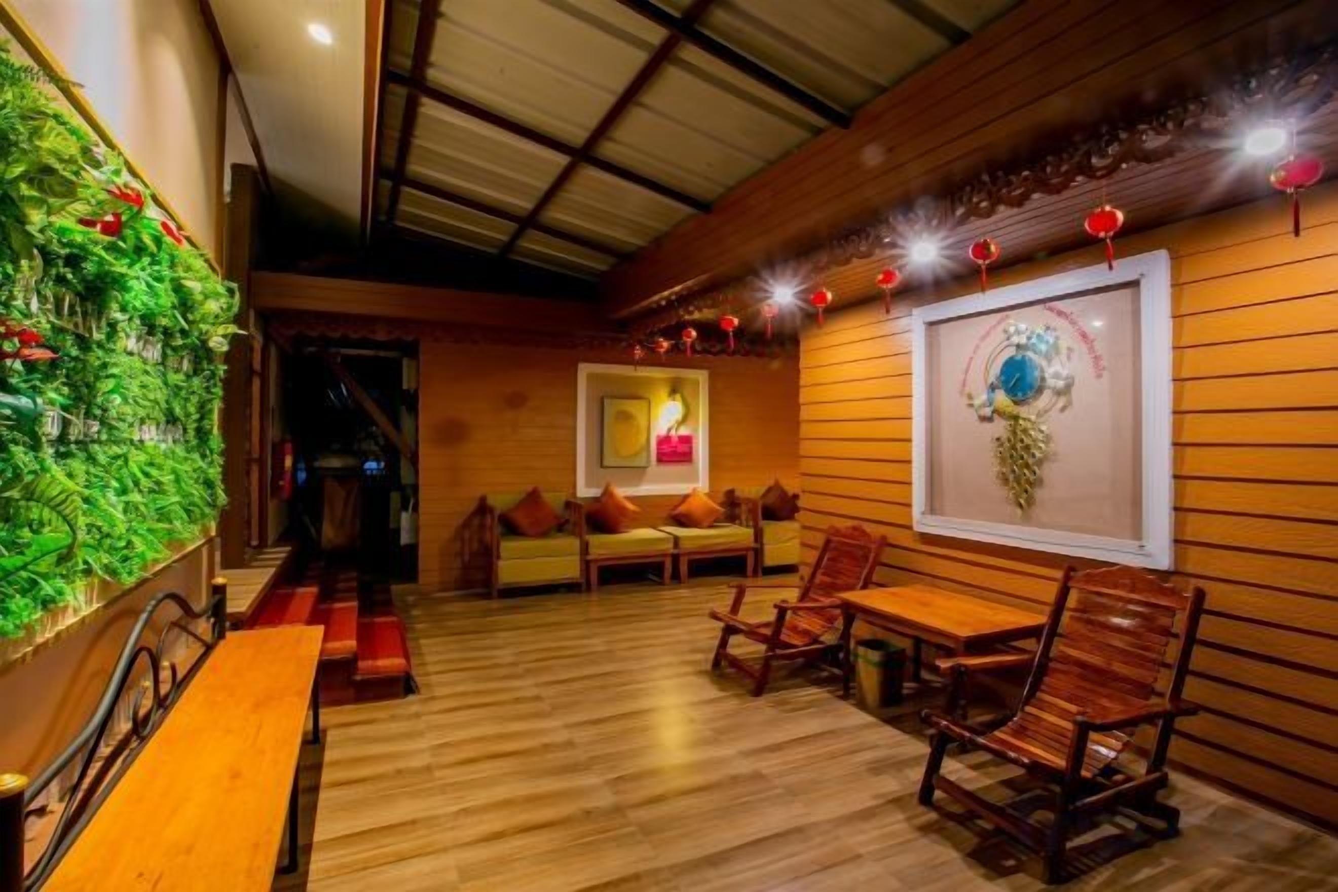 A restaurant interior with wooden walls, a green vertical garden, and traditional wooden furniture.
