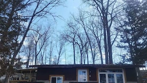 A small cabin with a front porch, a door, and a window.