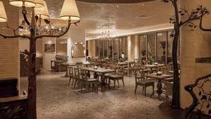 A spacious dining area with multiple tables and chairs, a chandelier, and a large mirror. - Le Recit Boutique Hotel De Dalat (Xuan Huong - Da Lat)