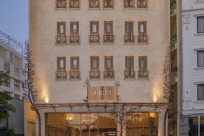 Fachada de hotel con un letrero que dice 'L'REXIT' y varias ventanas con balcones.