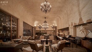 A spacious lobby with a high ceiling, chandeliers, and classic furniture. - Le Recit Boutique Hotel De Dalat (Xuan Huong - Da Lat)