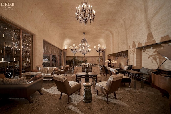 Eine geräumige Lobby mit hoher Decke, Kronleuchtern und klassischer Möbel.