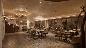 A spacious, elegantly furnished dining area with multiple tables and chairs, chandeliers, and large windows offering views of the interior. - Le Recit Boutique Hotel De Dalat (Xuan Huong - Da Lat)
