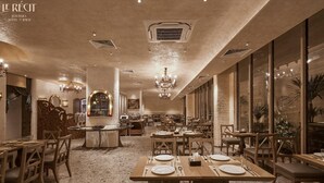 A spacious restaurant with high ceilings, chandeliers, and a warm color palette. Tables are set for dining, and the floor is tiled. - Le Recit Boutique Hotel De Dalat (Xuan Huong - Da Lat)