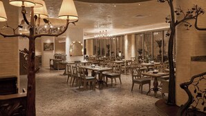 A spacious dining area with multiple tables and chairs, a chandelier, and a decorative tree sculpture. - Le Recit Boutique Hotel De Dalat (Xuan Huong - Da Lat)