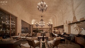 A spacious lobby with a high ceiling, chandeliers, and classic furniture. - Le Recit Boutique Hotel De Dalat (Xuan Huong - Da Lat)