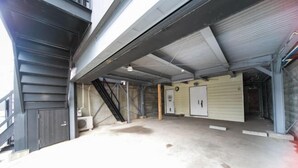 Ein geräumiges Gebäude im Industriedesign mit Betonboden, Metalltreppen und großen Toren.