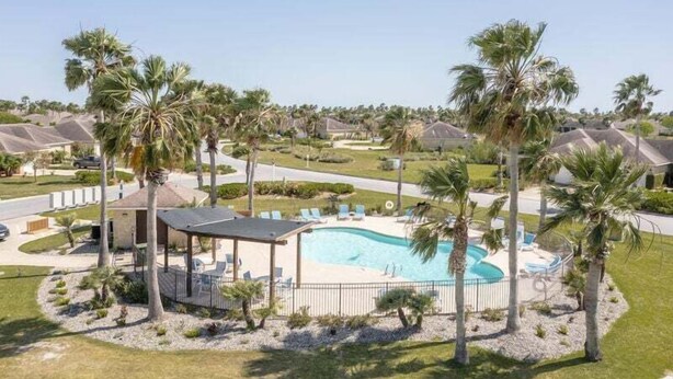 A residential area with a swimming pool surrounded by palm trees and a gazebo. - Chic Villa By The Bay- 48 TP (Laguna Vista)