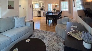 A spacious living room with a sofa, a coffee table, and a dining area with a table and chairs.