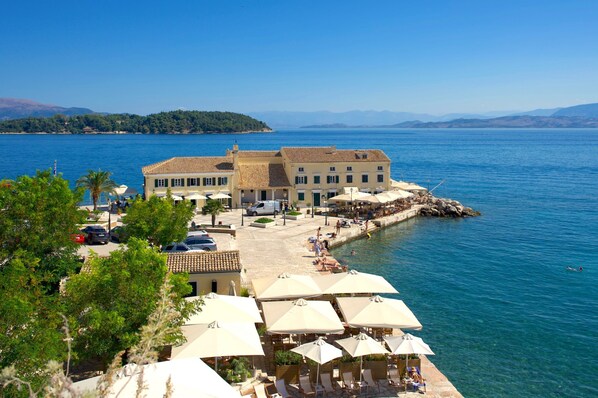 Un hotel costero con terraza con vistas al mar, con asientos exteriores y vista al agua.