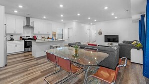 Ein modernes Apartment mit Küche, Essbereich und Wohnzimmer.