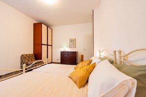 A bedroom with a bed, a dresser, a chair, and a painting on the wall. - GuestHost - Colorful 60 sqm apartment with balcony, just a 5-minute walk from the sea. The accommodation is located on the first floor of a building with lift and can host up to 2 guests.The building is situated in a quiet residential area, well served b (Pescara)