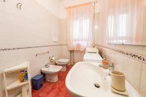 A bathroom with a bidet, toilet, sink, and a shower curtain. - GuestHost - Colorful 60 sqm apartment with balcony, just a 5-minute walk from the sea. The accommodation is located on the first floor of a building with lift and can host up to 2 guests.The building is situated in a quiet residential area, well served b (Pescara)