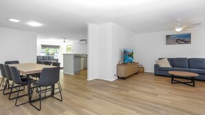 Ein modernes Wohnzimmer mit Essbereich, Küche und Balkon.